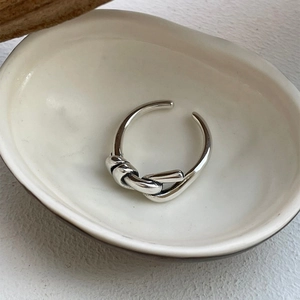 Detailed view of 925 sterling silver knot ring featuring a polished intertwined design