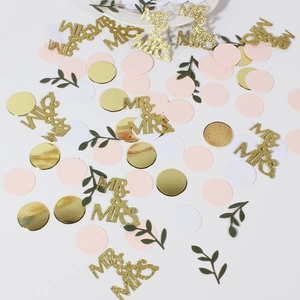 Detail von Mr & Mrs Gold-Glitzer-Konfetti mit rosa-weißen Kreisen und grünen Blättern