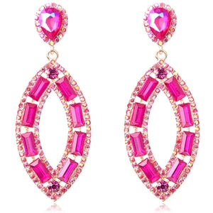 Macro view of hot pink crystal earrings with oval gold pendants and teardrop studs