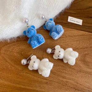 Cute flocked bear earrings with pearl studs in blue and white on a soft sweater