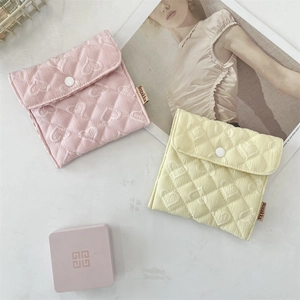 Dettaglio di pochette trapuntate jacquard a cuori in rosa e giallo con chiusura a scatto