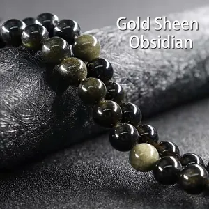 Macro shot of 10-12mm gold sheen obsidian beads with natural cat eye effect on a dark base