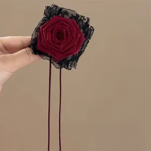 Macro shot of retro dark red satin rose hair tie with black lace trim and ribbons