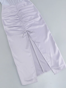 Close-up of purple satin dress featuring drawstring ruching and a stylish side slit detail