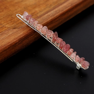 Detailansicht der silbernen Haarnadel mit rosa Naturkristallsteinen auf einem Holztablett