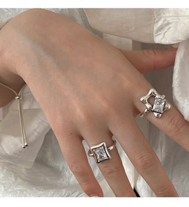 Detail of 925 sterling silver rings with irregular liquid metal texture and square gems