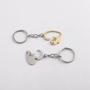 Detail of kissing cat keychains in gold and silver finish with heart-shaped tails