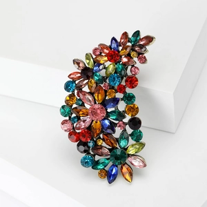 Macro view of vintage bronze crescent brooch with colorful glass crystals and gemstones