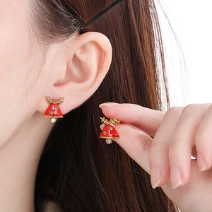 Detail of festive Christmas bell earrings with golden antlers and crystal accents
