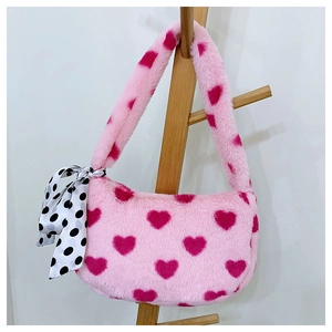 Detail of pink plush shoulder bag with dark pink heart patterns and polka dot silk scarf