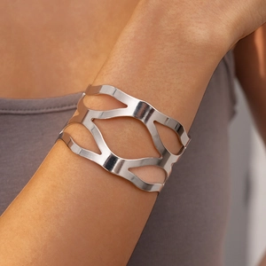 Détail d'un bracelet manchette argenté irrégulier avec motif géométrique ajouré