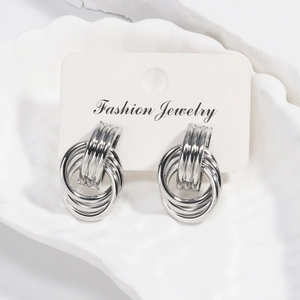 Silver multi-layered hoop earrings with tassel detail on a white shell display tray