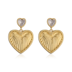 Elegant gold heart earrings with sparkling crystals shown on white reflective background
