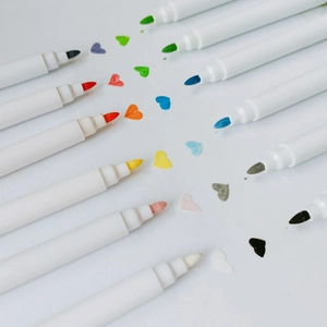Bunte Flüssigkreide-Marker mit Faserspitzen und herzförmigen Farbmustern auf weißem Grund