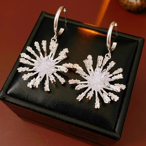 Gros plan de boucles d'oreilles flocon d'argent avec zircons sur un coffret