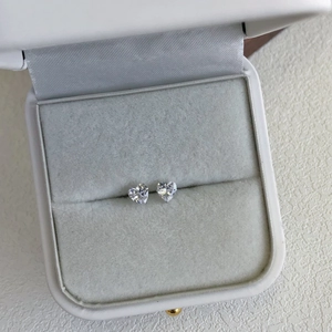 Macro detail of heart-shaped S925 sterling silver studs with zircon in a jewelry box