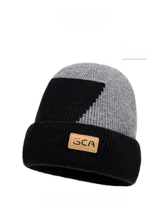 Dettaglio del berretto in maglia bicolore nero e grigio con toppa in pelle GCA calda