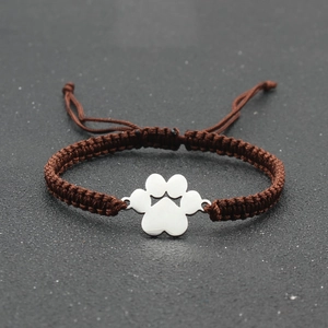 Close-up of adjustable brown woven rope bracelet with silver metal paw print charm