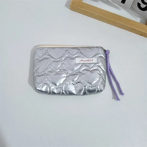Top view of silver heart-quilted coin purse with purple woven cord and zipper