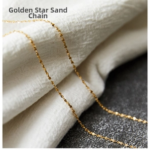 Close-up of golden sparkling star sand chain necklace on elegant white fabric