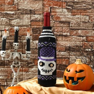 Halloween wine bottle cover featuring a knitted skeleton with a purple hat and pumpkins