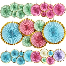 Detailed view of colorful paper fans with gold trim for party background decoration