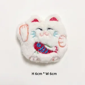 Detail view of 6x6cm plush lucky cat brooch with embroidery and red carp fish