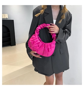 Fashionable magenta pleated cloud bag styled with a grey blazer for a modern street look