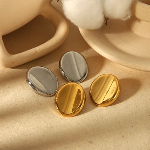 Boucles d'oreilles ovales polies en or 18 carats et argent sur tissu beige texturé