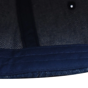 Dettaglio macro delle cuciture interne di un cappello da baseball in denim lavato blu navy