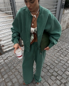 Streetstyle-Aufnahme eines grünen Sweatshirts mit Reißverschluss und passender Hose