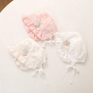 Détail de chapeaux de soleil en dentelle pour bébé avec broderie fraise et volants