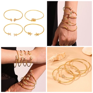 Détails de quatre bracelets en acier titane doré avec breloques étoile de mer et poisson