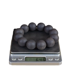 Polished ebony wood prayer beads bracelet on scale weighing 64.6 grams for jewelry making