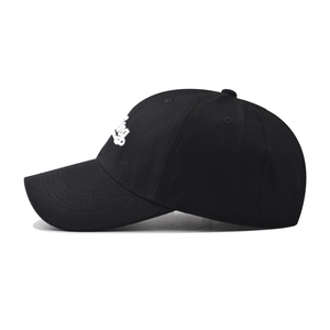 Detailed close-up of white letter embroidery on a black cotton baseball cap fabric