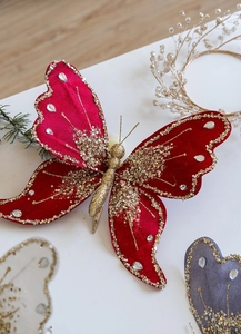 Macro detail of red velvet Christmas butterfly ornament with gold sequins and pearls