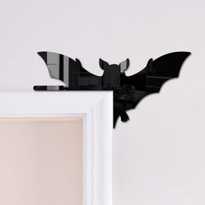 Detail of black acrylic bat mirror sticker applied on a white door frame corner
