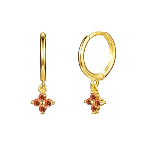 Detail of gold floral huggie earrings featuring four vibrant orange-red gemstones