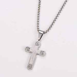 Macro shot of silver stainless steel box chain and cross pendant with detailed engraving