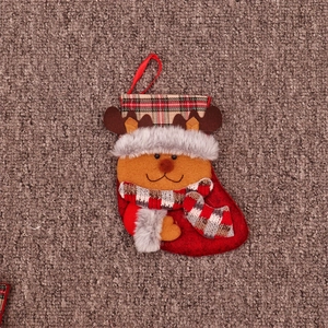 Détail d'une chaussette de Noël en feutre rouge avec renne 3D et motifs à carreaux