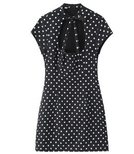 Detail of black polka dot mini dress with high tie-neck bow and teardrop cutout design
