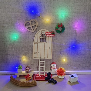 Miniature Christmas dollhouse kit with wooden elf door, snowman, and colorful LED lights