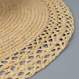 Detail of the raffia sun hat showing intricate spiral weave and hollow mesh pattern