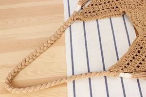 Detailed close-up of woven shoulder strap and hollow knit texture on a beige crochet bag