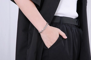 Gros plan d'un bracelet gourmette en acier inoxydable argenté avec fermoir OT au poignet