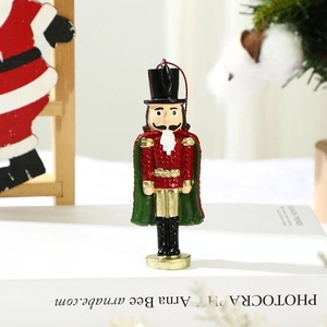 Close-up of glittery red and green nutcracker soldier ornament hanging on a Christmas tree