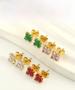 Gros plan de boucles d'oreilles trèfles plaquées or 18K avec zircons colorés