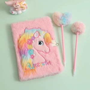 Detail view of pink plush unicorn notebook with matching fluffy heart-shaped pom-pom pens