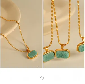 Macro shot of green amazonite stone pendant on a gold beaded stainless steel chain