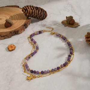 Detail of double-layer necklace with amethyst beads, gold chain, and starfish pendant